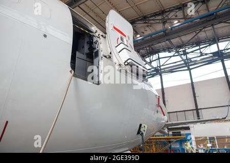 Open aircraft door and cocpit. Passenger airplane on maintenance repair in airport hangar Stock Photo