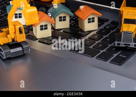 Home model  and construction vehicles on PC. Stock Photo