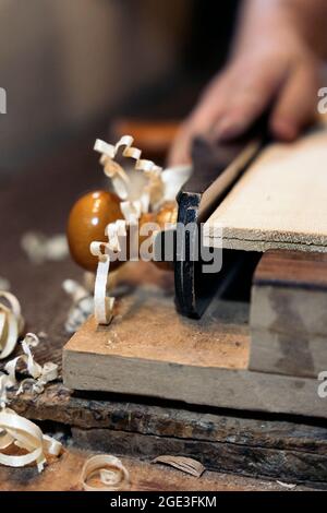 Unrecognized luthier working in his atelier and making a guitar. He is using a special tools. Stock Photo