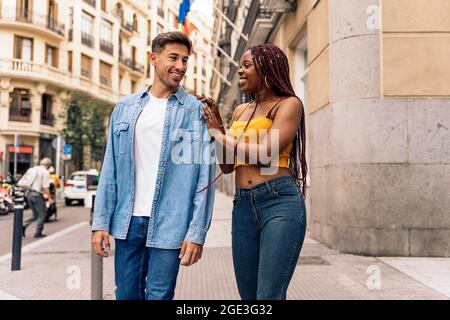 Multi-ethnic young couple walking in the streets of Madrid and having fun. Stock Photo
