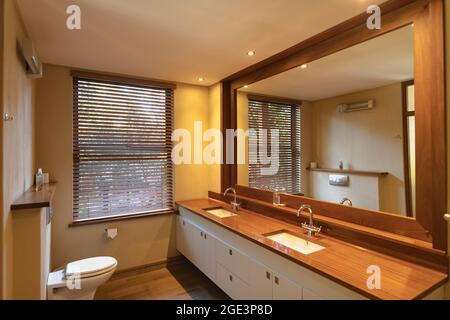 Interior of sunny, modern bathroom with beautiful big mirror Stock Photo