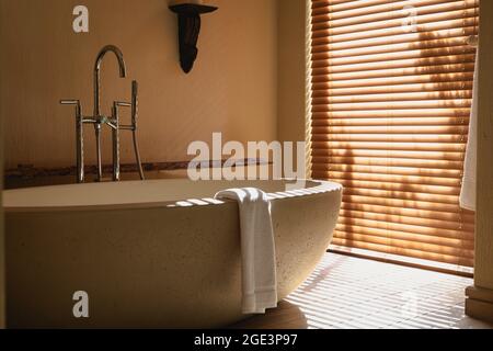 Interior of sunny, modern bathroom with beautiful designer bath Stock Photo