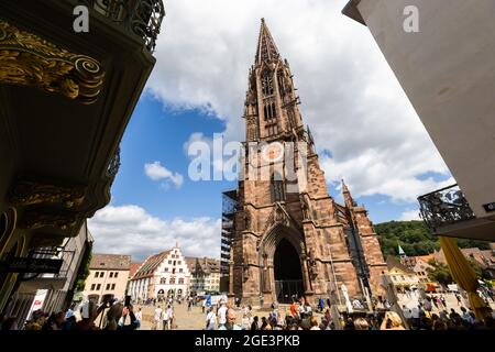 Freiburg, Germany. 16th Aug, 2021. People stand on Freiburg's Münsterplatz in front of the cathedral. Freiburg Cathedral is formally a cathedral, as Freiburg has been an episcopal see since 1827. The Archdiocese of Fribourg was formally established by Pope Pius VII on 16 August 1821 with the bull 'Provida solersque'. Credit: Philipp von Ditfurth/dpa/Alamy Live News Stock Photo