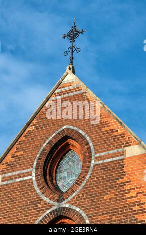 Ornate metal cross on the apex of the roof, All Souls Church, St Margarets, Twickenham, England, Church of England. Blue sky. Stock Photo