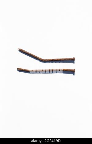 Two old rusty nails on white background. Stock Photo