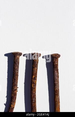 Three old rusty nails on white background. Stock Photo