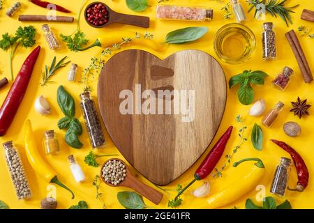Various herbs and spices on yellow background Stock Photo