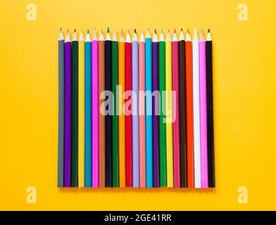 Colored wooden pencils on yellow background Stock Photo