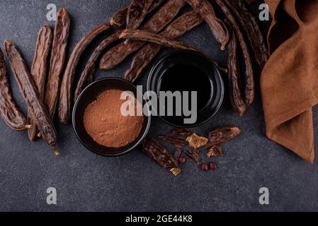 Carob pods, powder and molasses or syrup Stock Photo