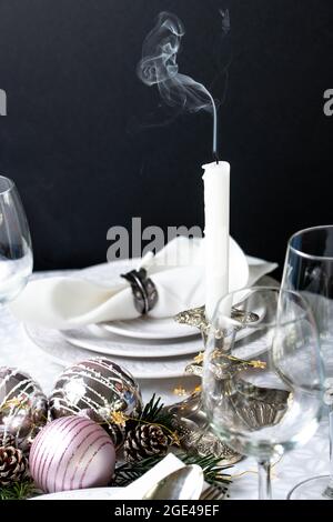 Christmas table setting with white napkins, antique sliver cutlery and candleholders Stock Photo