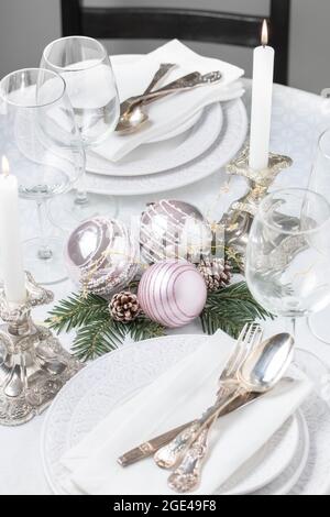 Christmas table setting with white napkins, antique sliver cutlery and candleholders Stock Photo