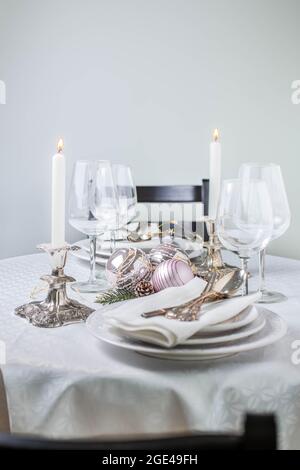 Christmas table setting with white napkins, antique sliver cutlery and candleholders Stock Photo