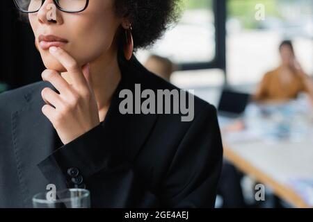 cropped view of african american businesswoman touching lip while thinking in office Stock Photo