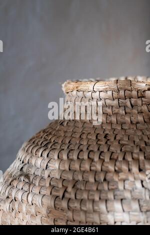 Background of very old wicker basket in grey background with copy space. Selective focus and image with shallow depth of field Stock Photo