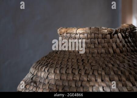 Background of very old wicker basket in grey background with copy space. Selective focus and image with shallow depth of field Stock Photo