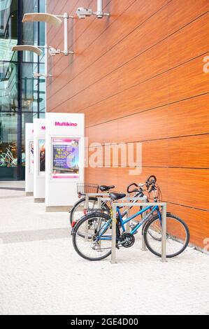 POZNAN, POLAND - Jan 31, 2016: Locked bicycles by Multikino advertisement boards in front of the Galeria Malta shopping mall Stock Photo