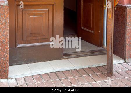 open wooden entrance doors with foot mat close-up of building architecture, nobody. Stock Photo