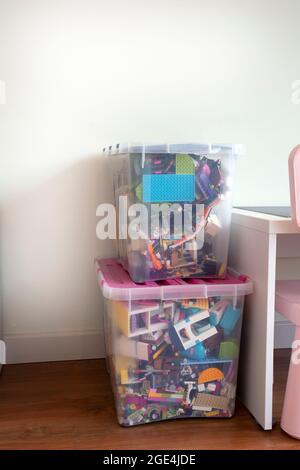 Plastic storage organizer toy box container case with colorful building blocks and other in playroom for children Stock Photo
