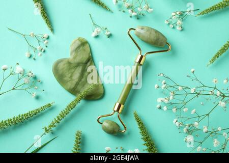 Skin care concept with face roller and gua sha on mint background Stock Photo