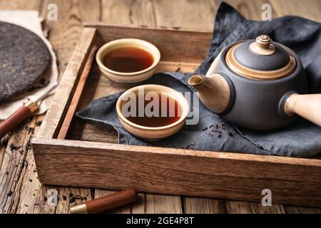 Medicinal Pu-erh tea in ceramic cups on wooden background Stock Photo