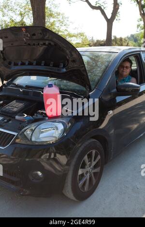 woman sitting in the car using the cell phone to call the roadside assistance service. Stock Photo
