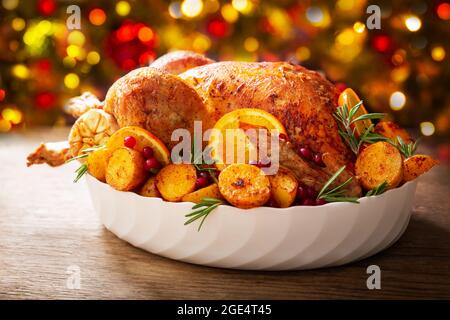 Christmas food. Baked turkey garnished with potato, oranges and  cranberries on a wooden table Stock Photo