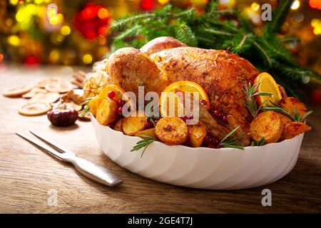 Christmas food. Baked turkey garnished with potato, oranges and  cranberries on a wooden table Stock Photo