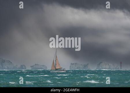 Sailing in the Solent just off the Needles off the coast of the Isle of Wight under a rainbow and very leaden skies Stock Photo