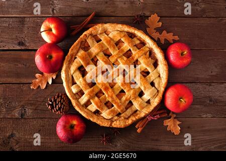 Homemade autumn apple pie, top view with frame of ingredients on a rustic wood table Stock Photo