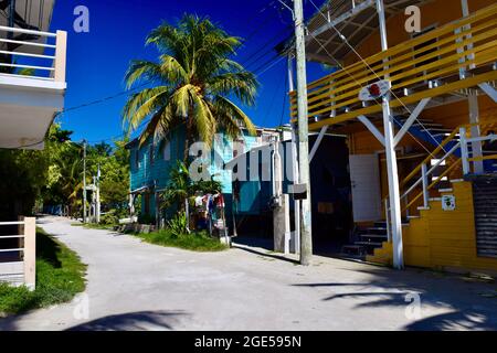 An unpaved road lined by colorful buildings on Caye Caulker, Belize Stock Photo