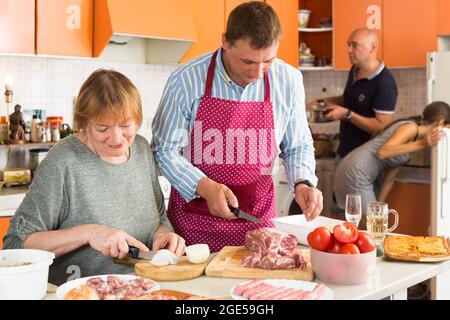 People cooking together in kitchen Stock Photo