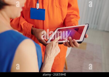 Senior woman rating service of technician via application on tablet computer Stock Photo