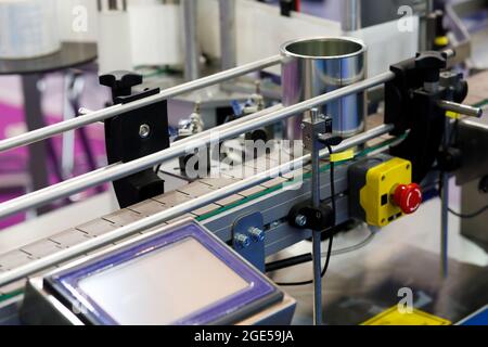 Automated production line with plastic modular conveyor belt. An empty tin can on a conveyor belt. Selective focus. Stock Photo