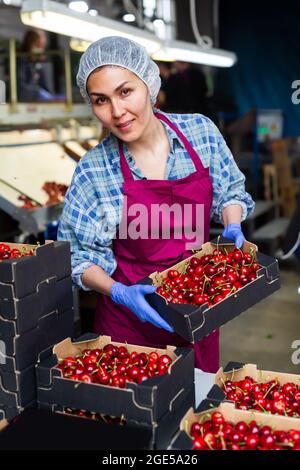 Woman in cherry warehouse Stock Photo