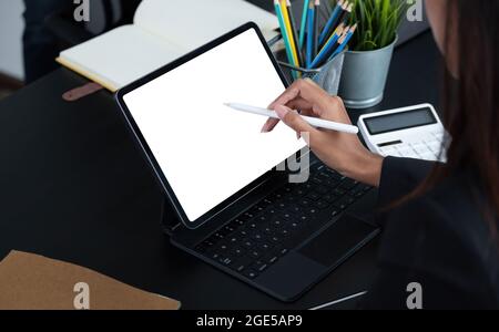 Cropped shot of a business woman sitting at modern office room and using blank screen digital tablet computer Stock Photo