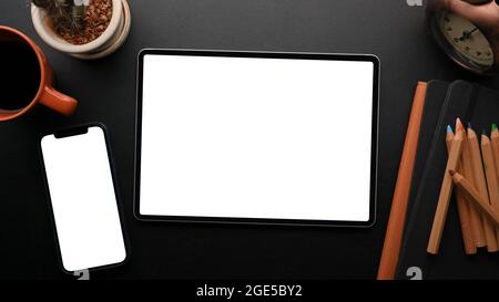 Touchscreen device objects concept, modern mobile phone and smart tablet blank screen mockup on black background with vintage decorations Stock Photo
