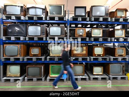 Heusenstamm, Germany. 10th Aug, 2021. Tina Kubot, Conservator of Media History, walks past a high rack of television sets in the Museum of Communication - Collections (slow shutter speed shot). On 22 August 1931, the first electronic television set was demonstrated at a technology show in Berlin. (to dpa 'The mother of all gawkers: Electronic television has 90th birthday'') Credit: Arne Dedert/dpa/Alamy Live News Stock Photo