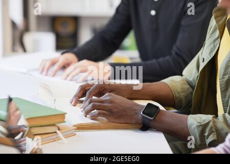 Side view closeup of inclusive group of students with young man reading braille book in library Stock Photo