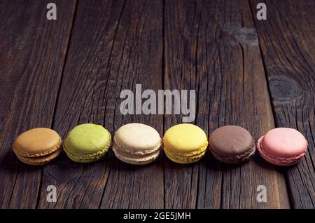 Colorful mini macaroons on dark wooden background with space for text Stock Photo