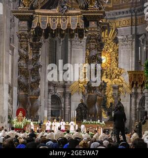Pope with mitre prays during Saint Mass in St. Peter's Basilica in front of faithful Christians, Saint Father, St. Peter's Basilica, Basilica di San Stock Photo