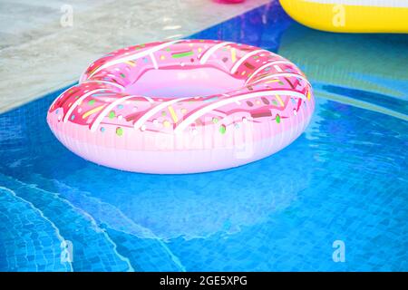 summer vacation. Relax by the pool. Inflatable ring, pink donut. Stock Photo