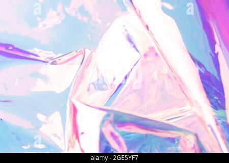 Defocused iridescent holographic background. Blurred colorful texture of wrinkled foil. Stock Photo