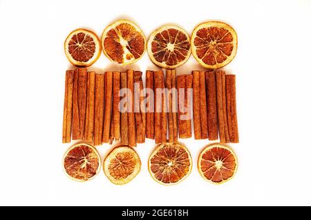 cinnamon sticks and dried grapefruits and oranges in slices on a white background. Grocery background of dried citrus slices. Stock Photo