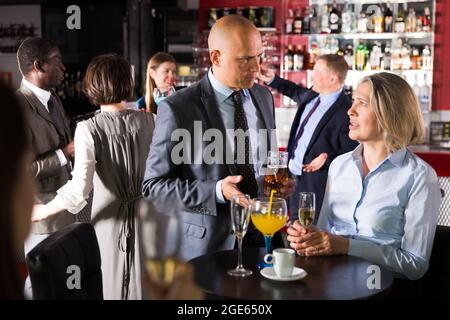 Upset mature woman talking to boss on corporate party Stock Photo