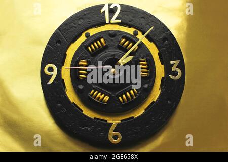 handmade watches on a gold background a clock from a car clutch disc black watch with gold elements trending color