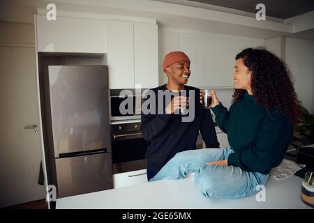 Happy, young African American couple drinking coffee. Mixed race couple looking at each other in the kitchen at home. High quality photo Stock Photo