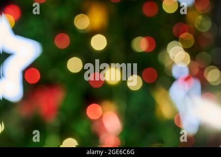 Blurred image of festive Christmas tree with decorations. Defocused christmas background. Merry Christmas background. Closeup shot of Christmas tree Stock Photo