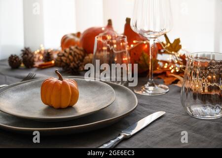 Halloween and Thanksgiving day dinner decorated fallen leaves, pumpkins, spices, grey plate. Close up. Vertical format. Stock Photo