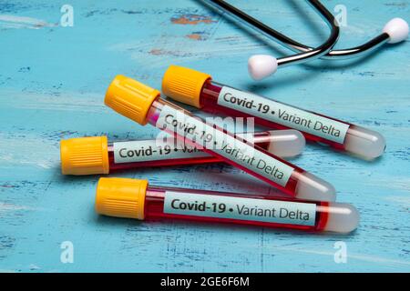 vacuum tube for blood collection, labeled Covid-19 - Variant Delta in a blue back ground Stock Photo