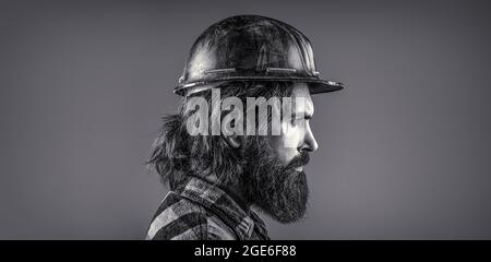 Man builders, industry. Builder in hard hat, foreman or repairman in the helmet. Black and white Stock Photo